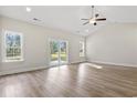 Bright living room with wood floors, vaulted ceiling, and sliding glass doors to the backyard at 639 Carter Reid Ct., Longs, SC 29568