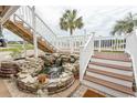 Inviting backyard water feature with rock accents, surrounded by well-maintained landscaping and stairs to the home at 526 Dogwood Dr. N, Garden City Beach, SC 29576