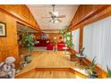 Cozy living room with warm wood paneling, hardwood floors, and ample natural light from large windows at 526 Dogwood Dr. N, Garden City Beach, SC 29576