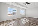 Bright, light-filled bedroom with wood floors, a modern ceiling fan, recessed lighting and a water view at 132 Oak Bay Dr., Georgetown, SC 29440