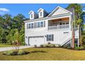 Side view of a charming two-story home with a covered porch, dormer windows, and landscaped yard at 132 Oak Bay Dr., Georgetown, SC 29440