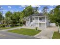 Charming two-story home features a welcoming front porch, well-maintained lawn, and a paved driveway at 615 N 17Th Ave. N, Surfside Beach, SC 29575