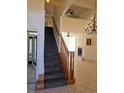 Bright foyer with staircase, chandelier, tile flooring, and an open view to the fireplace and living area at 144 Waterway Crossing Ct., Little River, SC 29566