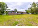 Brick ranch home with a large yard and American flag at 705 White Oak Dr., Johnsonville, SC 29555