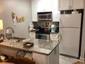 Functional kitchen with granite counters, modern appliances, and white cabinets at 118 Salt Marsh Circle # 25B, Pawleys Island, SC 29585