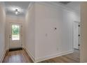 Bright foyer with white trim, wood-look floors, and a door with glass panes leading to the outside at 205 Brush Ct., Little River, SC 29566
