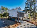 An inviting two-story home with a metal roof is situated on a stilt foundation in a picturesque setting at 189 Brown Pelican Loop, Pawleys Island, SC 29585