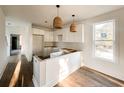 Modern white kitchen with new cabinets and wood flooring at 189 Brown Pelican Loop, Pawleys Island, SC 29585