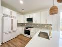 Modern kitchen featuring white cabinets, updated appliances, and gold hardware accents at 189 Brown Pelican Loop, Pawleys Island, SC 29585