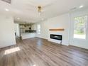 Open-concept living room with hardwood floors, fireplace, and seamless access to the kitchen at 189 Brown Pelican Loop, Pawleys Island, SC 29585