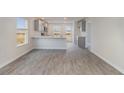 An open-concept room featuring new gray vinyl plank flooring, bright walls, and modern gray kitchen cabinetry at 116 Arbor Crest Ln., Tabor City, NC 28463