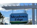 Meadows Edge community entrance sign against a partly cloudy blue sky at 1048 Oak Meadow Dr., Conway, SC 29526