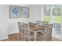 Bright dining area featuring a wooden table, six chairs, modern art, and sliding glass doors at 1068 Oak Meadow Dr., Conway, SC 29526