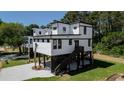 Stunning modern home featuring elevated design, stylish white siding, and eye-catching dark trim at 216 Brown Pelican Loop, Pawleys Island, SC 29585