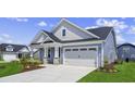 Side angle showcasing the home's architectural details, attached garage, and landscaped surroundings at 5001 Cambria Ct., Little River, SC 29566