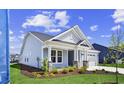Another view of the home's exterior, accentuating the front porch and the well-kept lawn and landscaping at 5001 Cambria Ct., Little River, SC 29566