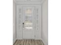Elegant front door with glass panels, complemented by white trim and modern hardware at 5001 Cambria Ct., Little River, SC 29566