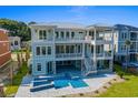 Elevated home with large pool, stone accents, and water views at 129 Serenity Point Dr., Little River, SC 29566