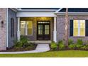 Inviting front porch with stylish columns, brick facade, and well-manicured landscaping for a warm welcome at 1531 Biltmore Dr., Myrtle Beach, SC 29579