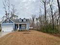 Beautiful blue home with a two-car garage, landscaped front yard and wooded area at 202 Rivers Edge Dr., Conway, SC 29526