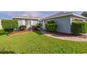 Manicured front lawn with lush green grass, trimmed bushes, and a stone walkway leading to the house at 213 Birkdale Ln., Myrtle Beach, SC 29588