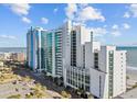 Beautiful oceanfront condo buildings with a stunning coastal view, complemented by lush palm trees lining the street at 201 S Ocean Blvd. # 1005, Myrtle Beach, SC 29577
