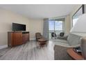 Cozy living room with comfortable seating, a TV, and a sliding glass door leading to a balcony with ocean views at 201 S Ocean Blvd. # 1005, Myrtle Beach, SC 29577