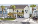 Coastal home featuring a charming two-story design with a wooden deck, ground floor lounge area, and a garage at 4524 Landing Rd., Little River, SC 29566