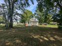 Spacious backyard with lush green grass, mature trees offering ample shade, and a single-story home at 114 Henry Mcgill St., Marion, SC 29571