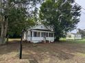 Front exterior view of a single-story home, set back from the street with a covered porch and mature trees at 114 Henry Mcgill St., Marion, SC 29571