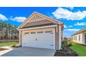 Exterior shot of a two-car garage with a white door and trim, complemented by manicured landscaping at 626 Castle Ct., Myrtle Beach, SC 29579