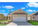 Exterior shot showcasing the home's two-car garage with white door and complementary landscaping at 626 Castle Ct., Myrtle Beach, SC 29579