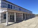 Townhome exterior showcases a covered entry and ample natural light, awaiting finishing touches for comfortable living at 6876 Watertower Rd. # 206, Longs, SC 29568