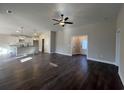 Open-concept living room and kitchen area with dark wood floors and modern light fixtures at 1033 Sioux Swamp Dr., Conway, SC 29527