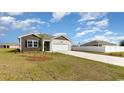 House exterior view showing a front yard with landscaping and driveway at 3865 Lady Bug Dr., Shallotte, NC 28470