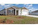 Exterior view of a charming house with landscaping and a white fence at 3865 Lady Bug Dr., Shallotte, NC 28470