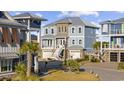 Three-story house with gray siding, stone accents, and a paved driveway at 113 Serenity Point Dr., Little River, SC 29566