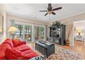 Bright living room featuring hardwood floors, a red sofa, and sliding doors to the outside patio space at 601 Hillside Dr. N # 2903, North Myrtle Beach, SC 29582