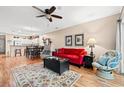 Open living space with a red sofa, accent chairs, hardwood floors, and seamless flow into the dining area at 601 Hillside Dr. N # 2903, North Myrtle Beach, SC 29582