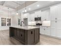 Bright, modern kitchen with white cabinetry, quartz countertops, stainless appliances, and an island at 2264 Pearl Rd., Galivants Ferry, SC 29544