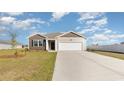 Attractive home showcasing a two-car garage, neutral siding, and a long concrete driveway at 314 Cheerful Way, Little River, SC 29566