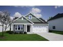 Craftsman style home, green siding, white garage door, and manicured lawn at 714 Night Lotus Dr., Calabash, NC 28467