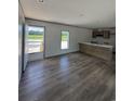 Open-concept living space with wood-look floors, a kitchen island, and natural light streaming through the windows at 2494 Newton Rd., Aynor, SC 29511