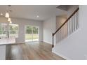 Bright living room with hardwood floors, sliding glass door, and staircase at 607 Mccorkle Place, Conway, SC 29526