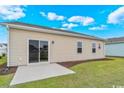 Simple backyard showcasing a sliding glass door, patio, and a well-kept lawn at 3038 Deerberry Place, Longs, SC 29568