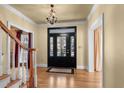 Welcoming foyer showcasing hardwood floors, chandelier, and a glass-paneled front door allowing natural light at 4569 Carriage Run Circle, Murrells Inlet, SC 29576