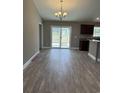 Open-concept living room featuring wood floors, sliding glass door, and stylish light fixture at Tbb4 Privetts Rd., Conway, SC 29526