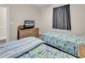 Twin beds with ocean-themed bedding and a wicker dresser with a TV in this cozy bedroom at 4709 Wild Iris Dr. # 104, Myrtle Beach, SC 29577