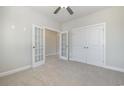 Spacious bedroom with neutral carpet, ceiling fan, double doors, and closet space at 107 Infinity Ln., Loris, SC 29569