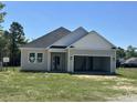 New home features neutral siding, white trim, and an attached two-car garage on a sunny day at 108 Infinity Ln., Loris, SC 29569